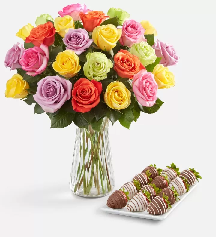 Assortment of vibrant red, pink, and yellow roses alongside drizzled strawberries