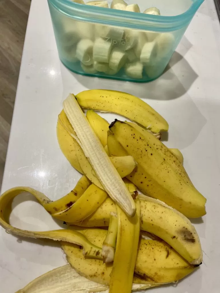 Banana peels soaking in a glass jar filled with water to create nutrient-rich liquid fertilizer for plants.
