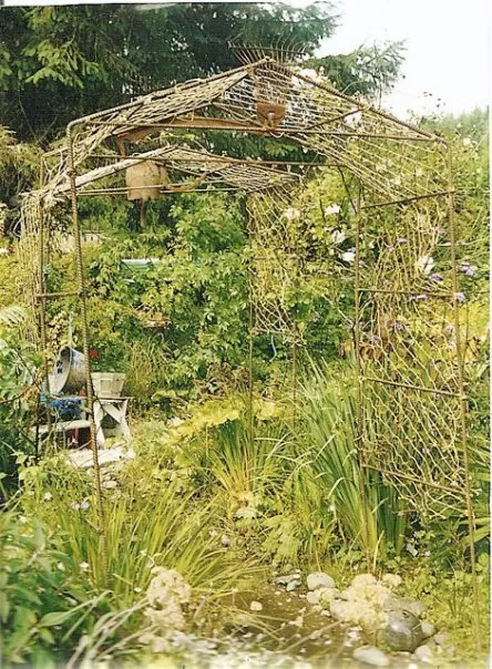 Handcrafted metal arbors made of rebar in a lush garden setting.