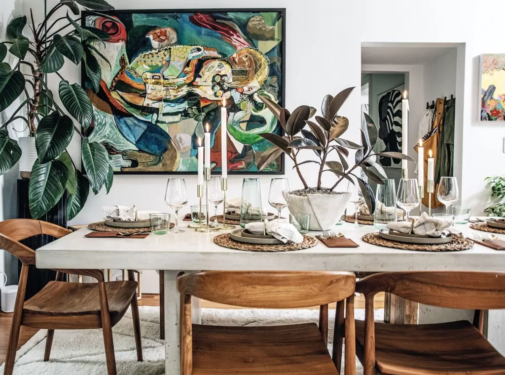Lush interior filled with a variety of houseplants, including large potted plants and smaller trailing vines spilling from shelves and containers, creating a vibrant, layered green space.